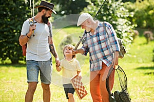 Summer weekend. Happy grandfather, father and grandson with fishing rods. Anglers. Men day. Fishing. photo