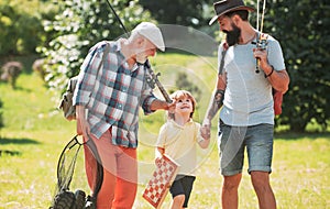 Summer weekend. Happy grandfather, father and grandson with fishing rods. Anglers. Men day. Fishing.