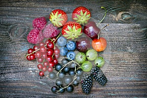 Summer wild berry fruits on vintage board still life