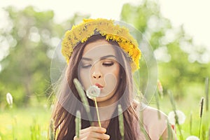 Summer woman blowing on dandelion flowers