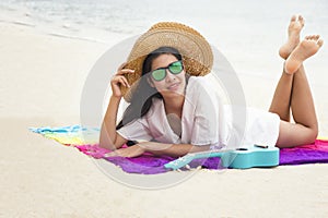 Summer woman relaxing in hipster beach hat and colorful sunglasses. Funky happy girl having fun during travel holidays vacation.
