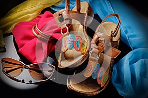 Summer women`s accessories : bracelets, leather sandals, sun glasses. Close up.