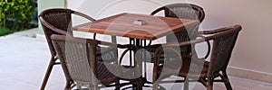 Summer wooden table and wicker chairs on veranda