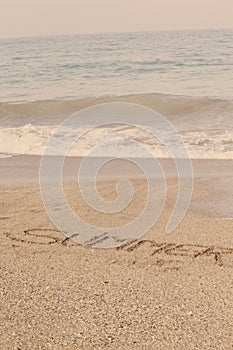 Summer written in soft wet sand on a beach, Dubai-1 September 2017