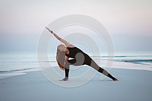 Summer yoga session on a beautiful golden beach of Maldives yoga tour, Extended Side Angle Pose Utthita Parsvakonasana photo