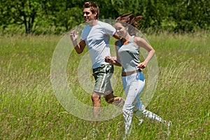 Summer - Young couple jogging in a meadow