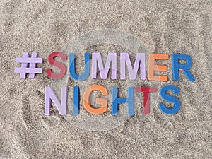 #summernights summer nights written on sand at the beach