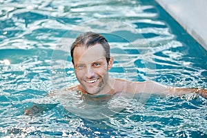 Summertime is all about swimming the days away. Portrait of a handsome man swimming in a pool.