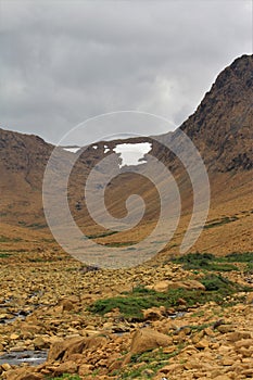 Summertime clouds over desolate other-worldly Tablelands National Park: rock-strewn Winterhouse Brook in the foreground