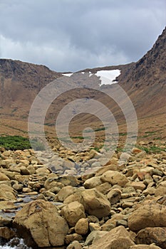 Summertime clouds over desolate other-worldly Tablelands National Park: rock-strewn Winterhouse Brook in the foreground glaciate