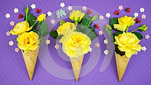 Summertime concept with ice cream cones filled with fruit, flowers and candy.