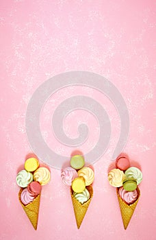 Summertime decorated border of ice cream cones with macarons and meringues.