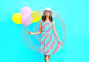 Summertime! Fashion happy smiling young woman holds an air colorful balloons