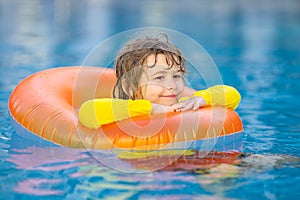 Summertime fun. Little kid swimming in pool. Kid in swimming pool relax and swim on inflatable ring. Summer vacation