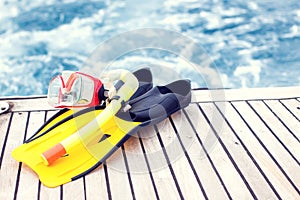 Summertime and holiday concept. Sea view. Diving mask and flippers lelft on boat