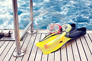 Summertime and holiday concept. Sea view. Diving mask and flippers lelft on boat