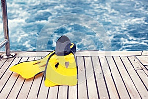 Summertime and holiday concept. Sea view. Diving mask and flippers lelft on boat