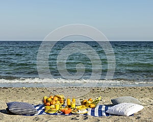 Summertime. A picnic on the beach. Burgers and pitas, vegetables and fruits.