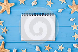 Summertime relax concept. Top above overhead view photo of blank notebook with seashells and seafish around isolated on blue