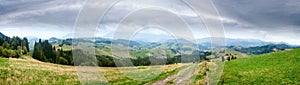 Summertime rural landscape banner, panorama - view at dirt road against the background of mountains Western Carpathians