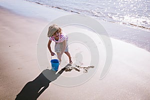 Summertime: Smiling Young Girl Plays on a Beach