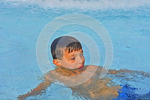 Summertime and swimming activities for happy children in the pool. Cute boy in water park. Summer and happy chilhood concept
