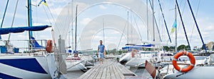 Summertime vacation journey adventure concept. Handsome man spending free time walking on marina