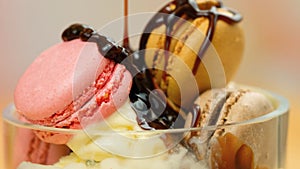 Vanilla ice cream macro closeup with chocolate sauce and macron cookies.