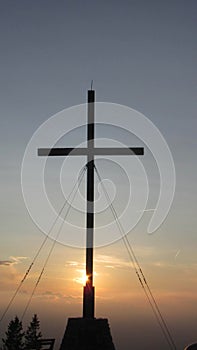 Summit cross on top of the mountain at sunset