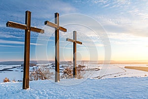 Summit crosses on a mountain peak in a beautiful winter landscape in the Swabian Alps at sunset