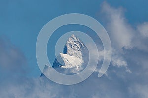Summit of Finsteraarhorn mountain in clouds, blue sky photo