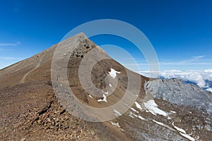 Summit of Uri Rotstock mountain in Swiss alps, blue sky, sea of fog