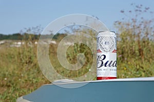 SUMY, UKRAINE - AUGUST 01, 2021: Can of Budweiser Lager Alcohol Beer on overturned kayak boat outdoors. Budweiser is a Brand from