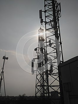 The sun above the cellphone signal transmitting tower photo