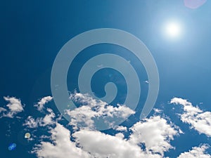 Sun on a background of blue sky with clouds