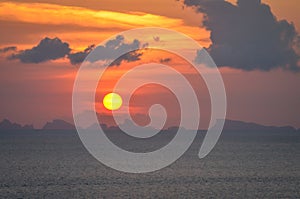 Sun ball hides behind clouds infernal dramatic and colorful sunset photo