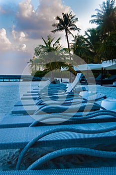 Sun beds chairs kept in line on sea beach