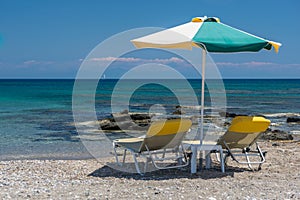 Sun beds and an umbrella on the beach, on the seashore