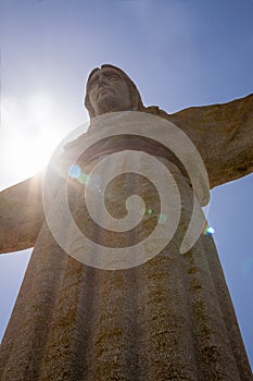 Sun behind Christus Rei Statue in Lisbon, Portugal photo