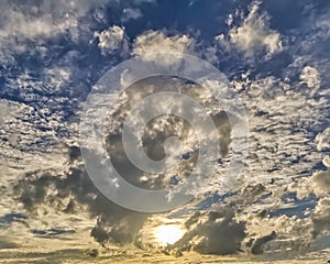 Sun behind clouds with blue sky