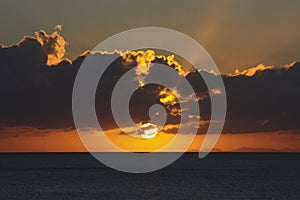 Sun behind clouds in a nice sea sunset