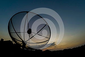 Sun behind satellite receiver in twilight