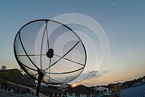 Sun behind satellite receiver in twilight