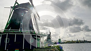 Sun behind several windmills at zaanse schans near amsterdam