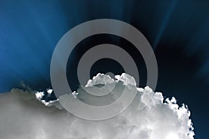 Sun behind the white cloud. Dramatic blue sky with sun rays