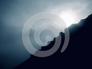 the sun breaking through the mountain mist