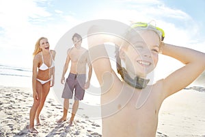 Sun brings out the fun. a happy little boy wearing goggles while spending a day with his parents at the beach.