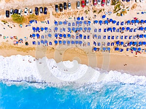 Sun chairs and umbrellas bird`s eye view on sand beach in Greece