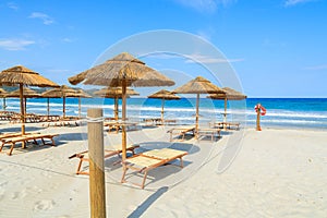 Sun chairs with umbrellas on Porto Giunco sandy beach, Sardinia island, Italy