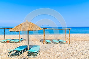 Sun chairs with umbrellas on Potami beach, Samos island, Greece